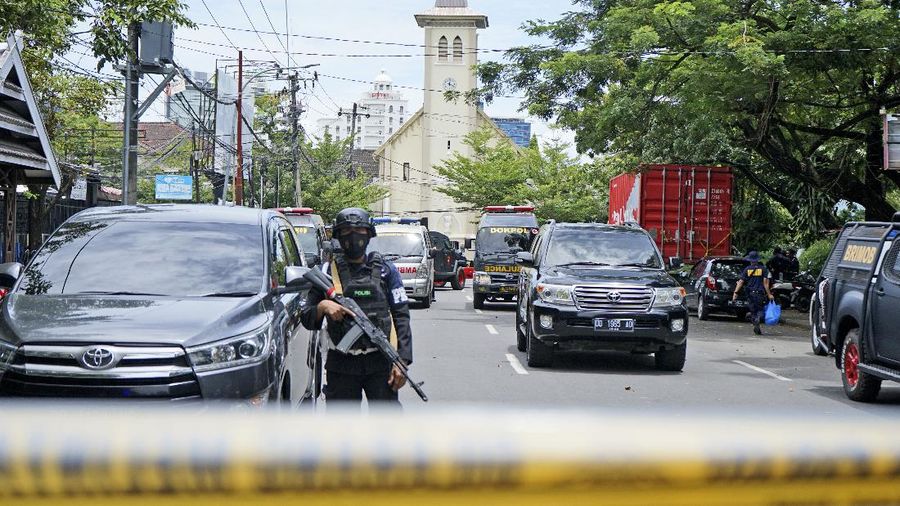 A police officer stands guard near a church where an explosion went off in Makassar, South Sulawesi, Indonesia, Sunday, March 28, 2021. Police in Indonesia say at least one suicide bomber has detonated outside a packed Roman Catholic cathedral during Sunday Mass, wounding several people. (AP Photo/Daeng Mansur)