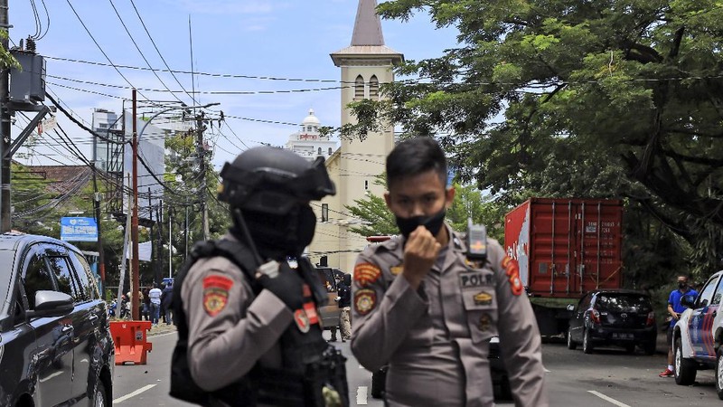 A police officer stands guard near a church where an explosion went off in Makassar, South Sulawesi, Indonesia, Sunday, March 28, 2021. Police in Indonesia say at least one suicide bomber has detonated outside a packed Roman Catholic cathedral during Sunday Mass, wounding several people. (AP Photo/Daeng Mansur)
