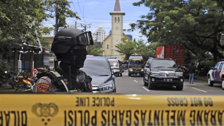 A police officer stands guard near a church where an explosion went off in Makassar, South Sulawesi, Indonesia, Sunday, March 28, 2021. (AP Photo/Yusuf Wahil)