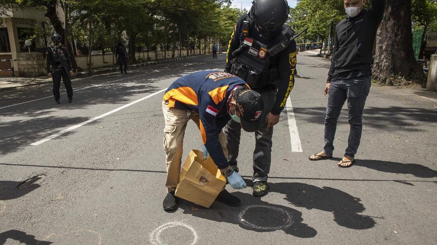 Police officer and rescue workers carry a body bag containing what is believed to be human remains outside a church where an explosion went off in Makassar, South Sulawesi, Indonesia, Sunday, March 28, 2021. A suicide bomber blew himself up outside a packed Roman Catholic cathedral on Indonesia's Sulawesi island during a Palm Sunday Mass, wounding a number of people, police said. (AP Photo/Masyudi S. Firmansyah)