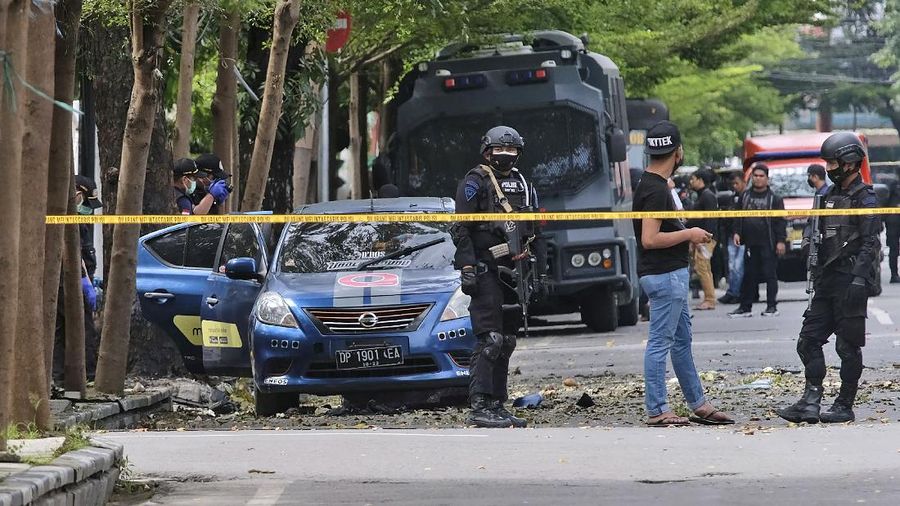 Police officer and rescue workers carry a body bag containing what is believed to be human remains outside a church where an explosion went off in Makassar, South Sulawesi, Indonesia, Sunday, March 28, 2021. A suicide bomber blew himself up outside a packed Roman Catholic cathedral on Indonesia's Sulawesi island during a Palm Sunday Mass, wounding a number of people, police said. (AP Photo/Masyudi S. Firmansyah)