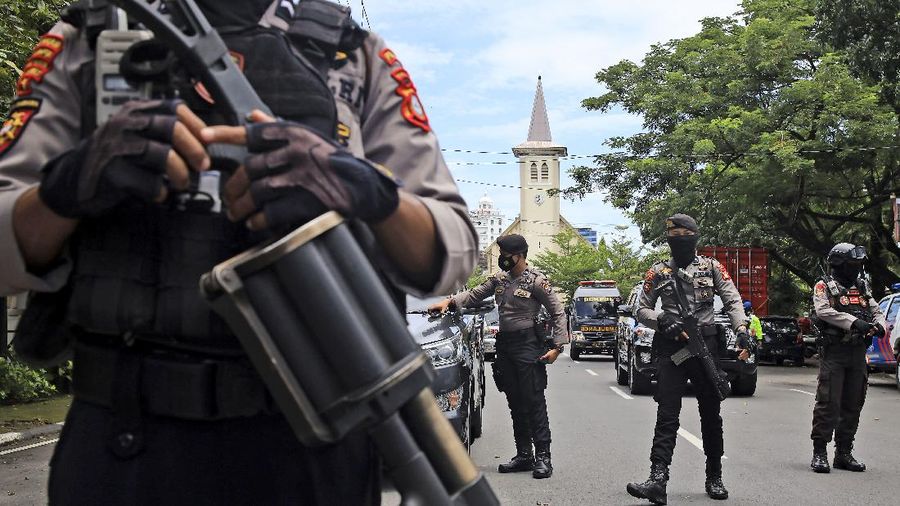 A police officer stands guard near a church where an explosion went off in Makassar, South Sulawesi, Indonesia, Sunday, March 28, 2021. (AP Photo/Yusuf Wahil)