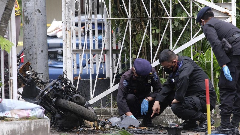 Police officers stand guard during a raid on a house that, police believe, is linked to the suicide bombers of Sunday's church attack, in Makassar, South Sulawesi, Indonesia, Monday, March 29, 2021. Two attackers believed to be members of a militant network that pledged allegiance to the Islamic State group blew themselves up outside the packed Roman Catholic cathedral during a Palm Sunday Mass on Indonesia's Sulawesi island, wounding a number of people, police said. (AP Photo/Daeng Mansur)