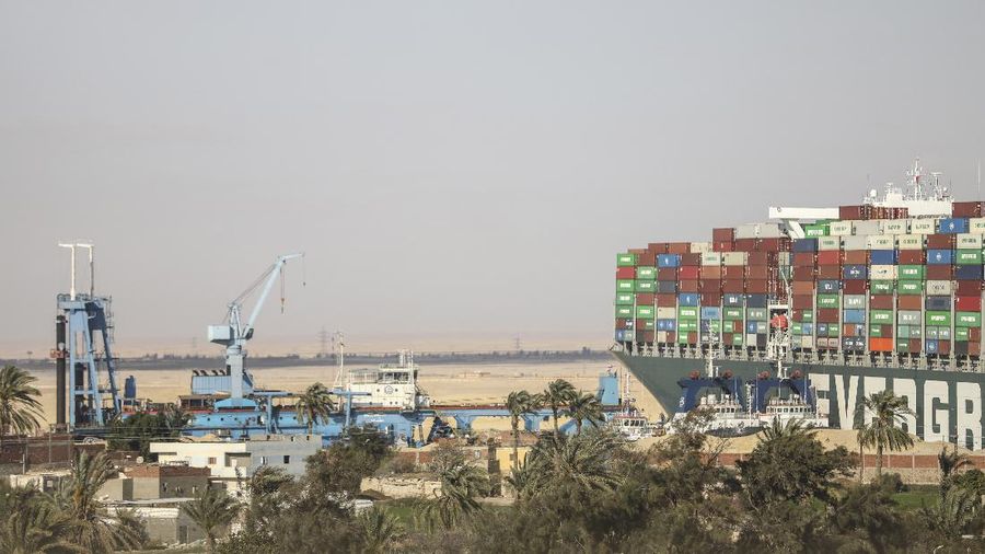 Ever Given, a Panama-flagged cargo ship that is wedged across the Suez Canal and blocking traffic in the vital waterway is seen Sunday, March 28, 2021. The massive Ever Given, a Panama-flagged, Japanese-owned ship that carries cargo between Asia and Europe, got stuck Tuesday in a single-lane stretch of the canal. In the time since, authorities have been unable to remove the vessel and traffic through the canal has been halted,(AP Photo/Mohamed Elshahed)