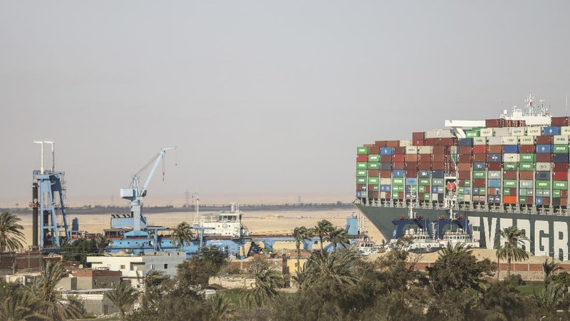 Ever Given, a Panama-flagged cargo ship that is wedged across the Suez Canal and blocking traffic in the vital waterway is seen Sunday, March 28, 2021. The massive Ever Given, a Panama-flagged, Japanese-owned ship that carries cargo between Asia and Europe, got stuck Tuesday in a single-lane stretch of the canal. In the time since, authorities have been unable to remove the vessel and traffic through the canal has been halted,(AP Photo/Mohamed Elshahed)