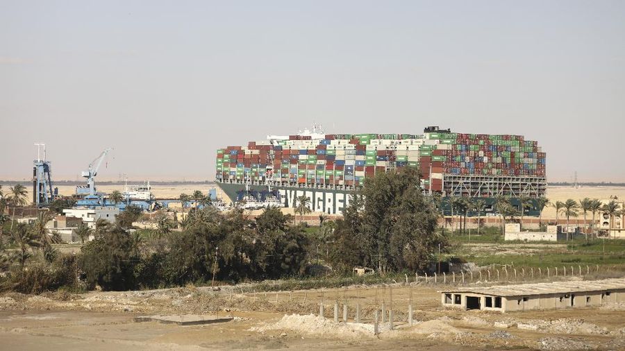 Ever Given, a Panama-flagged cargo ship that is wedged across the Suez Canal and blocking traffic in the vital waterway is seen Sunday, March 28, 2021. The massive Ever Given, a Panama-flagged, Japanese-owned ship that carries cargo between Asia and Europe, got stuck Tuesday in a single-lane stretch of the canal. In the time since, authorities have been unable to remove the vessel and traffic through the canal has been halted,(AP Photo/Mohamed Elshahed)