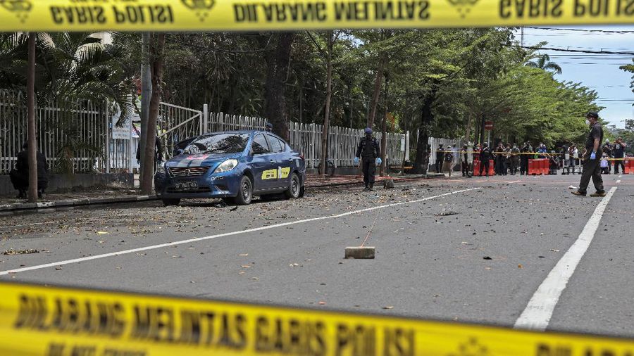 Police officers stand guard during a raid on a house that, police believe, is linked to the suicide bombers of Sunday's church attack, in Makassar, South Sulawesi, Indonesia, Monday, March 29, 2021. Two attackers believed to be members of a militant network that pledged allegiance to the Islamic State group blew themselves up outside the packed Roman Catholic cathedral during a Palm Sunday Mass on Indonesia's Sulawesi island, wounding a number of people, police said. (AP Photo/Daeng Mansur)