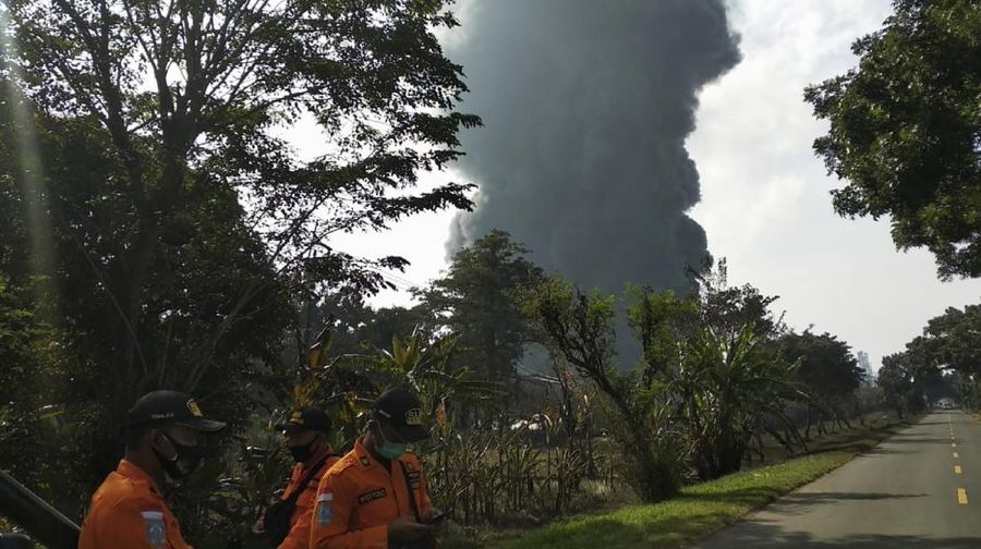 Motorists ride past as thick smoke billows from a fire that razes through Pertamina Balongan Refinery in Indramayu, West Java, Indonesia, Monday, March 29, 2021. Hundreds of people living in villages around the refinery have been evacuated following the fire that broke out after midnight on Monday. (AP Photo)