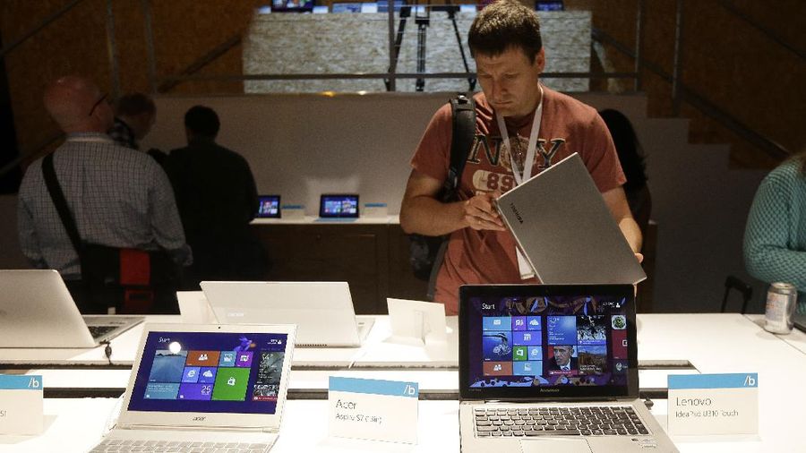 An Acer Aspire laptop, left, and a Lenovo IdeaPad U310 Touch are seen at a demo table at a Microsoft event in San Francisco, Wednesday, June 26, 2013. (AP Photo/Jeff Chiu)