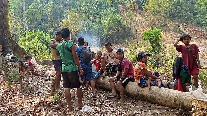 In this photo provided by Free Burma Rangers, villagers shelter in the open due to airstrikes, Saturday, March 27, 2021, in Deh Bu Noh, in Karen state, Myanmar. Myanmar military jets hit a village in Karen State, on Saturday night, killing a few people and wounding others, according to relief organizations.(Free Burma Rangers via AP)