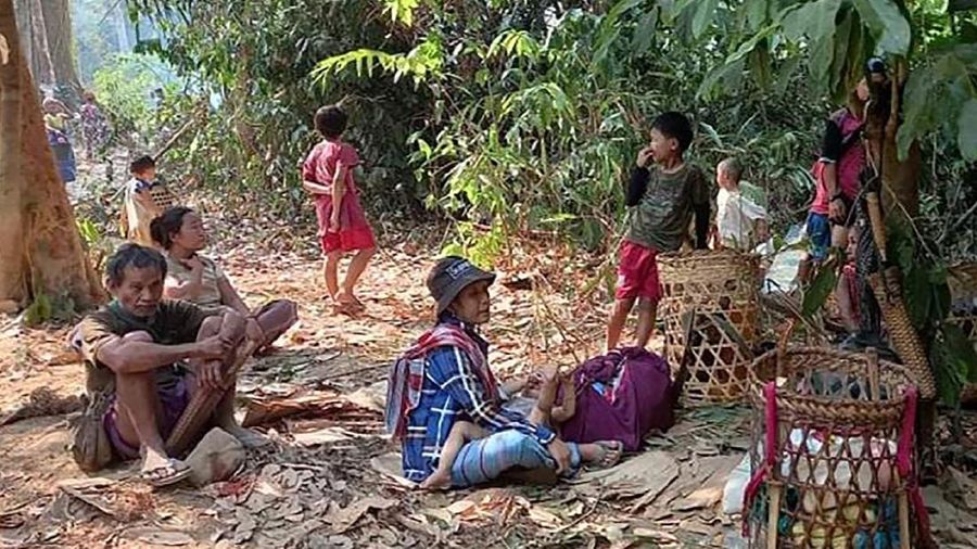 In this photo provided by Free Burma Rangers, villagers shelter in the open due to airstrikes, Saturday, March 27, 2021, in Deh Bu Noh, in Karen state, Myanmar. Myanmar military jets hit a village in Karen State, on Saturday night, killing a few people and wounding others, according to relief organizations.(Free Burma Rangers via AP)