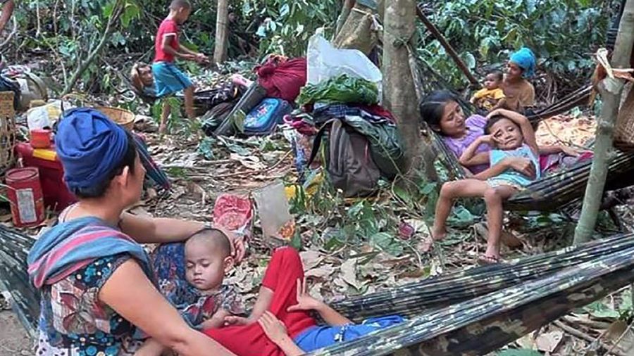 In this photo provided by Free Burma Rangers, villagers shelter in the open due to airstrikes, Saturday, March 27, 2021, in Deh Bu Noh, in Karen state, Myanmar. Myanmar military jets hit a village in Karen State, on Saturday night, killing a few people and wounding others, according to relief organizations.(Free Burma Rangers via AP)