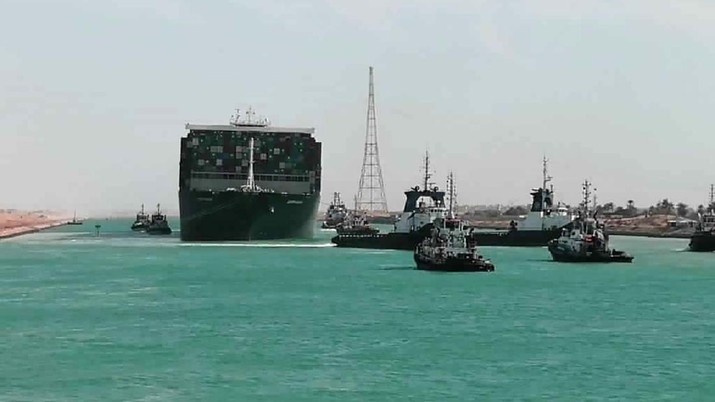 In this photo released by Suez Canal Authority, the Ever Given, a Panama-flagged cargo ship is accompanied by Suez Canal tugboats as it moves in the Suez Canal, Egypt, Monday, March 29, 2021. Salvage teams on Monday set free a colossal container ship that has halted global trade through the Suez Canal, bringing an end to a crisis that for nearly a week had clogged one of the world’s most vital maritime arteries. (Suez Canal Authority via AP)