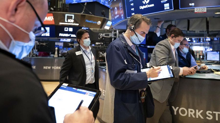 In this photo provided by the New York Stock Exchange, trader Americo Brunetti works on the floor, Thursday, March 25, 2021. Stocks are wobbling in afternoon trading Thursday as a slide in technology companies is being offset by gains for banks as bond yields stabilize.(Courtney Crow/New York Stock Exchange via AP)