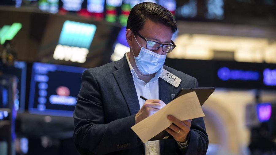 In this photo provided by the New York Stock Exchange, trader Americo Brunetti works on the floor, Thursday, March 25, 2021. Stocks are wobbling in afternoon trading Thursday as a slide in technology companies is being offset by gains for banks as bond yields stabilize.(Courtney Crow/New York Stock Exchange via AP)