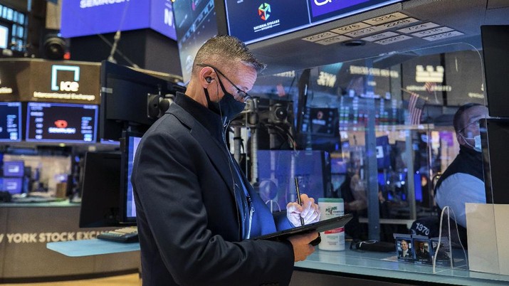 In this photo provided by the New York Stock Exchange, trader Americo Brunetti works on the floor, Thursday, March 25, 2021. Stocks are wobbling in afternoon trading Thursday as a slide in technology companies is being offset by gains for banks as bond yields stabilize.(Courtney Crow/New York Stock Exchange via AP)