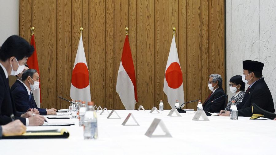 Japan's Prime Minister Yoshihide Suga, center, walks with Indonesian Foreign Minister Retno Marsudi, left, and Indonesian Defense Minister Prabowo Subianto after a photo session at the prime minister's official residence in Tokyo Tuesday, March 30, 2021. The Indonesian ministers are visiting Tokyo for security discussions focusing on China's growing assertiveness in regional seas. (AP Photo/Eugene Hoshiko, Pool)