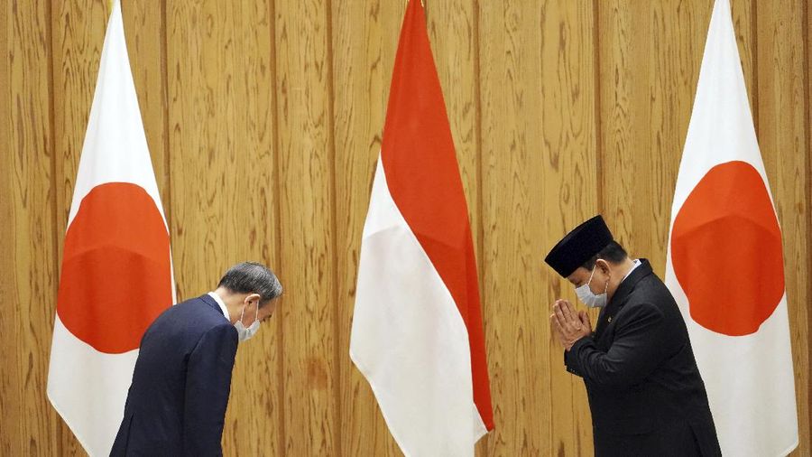 Japan's Prime Minister Yoshihide Suga, center, walks with Indonesian Foreign Minister Retno Marsudi, left, and Indonesian Defense Minister Prabowo Subianto after a photo session at the prime minister's official residence in Tokyo Tuesday, March 30, 2021. The Indonesian ministers are visiting Tokyo for security discussions focusing on China's growing assertiveness in regional seas. (AP Photo/Eugene Hoshiko, Pool)