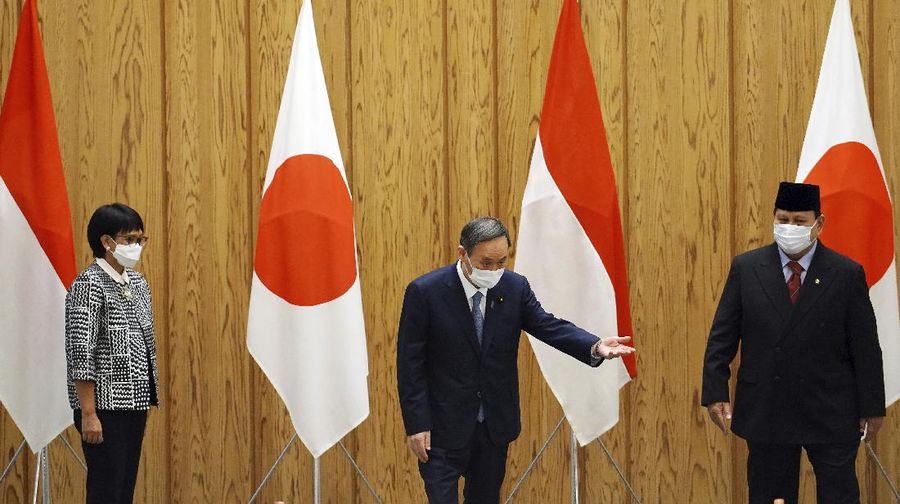 Japan's Prime Minister Yoshihide Suga, center, walks with Indonesian Foreign Minister Retno Marsudi, left, and Indonesian Defense Minister Prabowo Subianto after a photo session at the prime minister's official residence in Tokyo Tuesday, March 30, 2021. The Indonesian ministers are visiting Tokyo for security discussions focusing on China's growing assertiveness in regional seas. (AP Photo/Eugene Hoshiko, Pool)