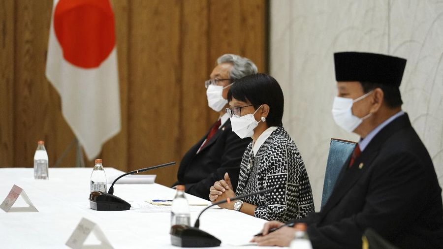 Japan's Prime Minister Yoshihide Suga, center, walks with Indonesian Foreign Minister Retno Marsudi, left, and Indonesian Defense Minister Prabowo Subianto after a photo session at the prime minister's official residence in Tokyo Tuesday, March 30, 2021. The Indonesian ministers are visiting Tokyo for security discussions focusing on China's growing assertiveness in regional seas. (AP Photo/Eugene Hoshiko, Pool)