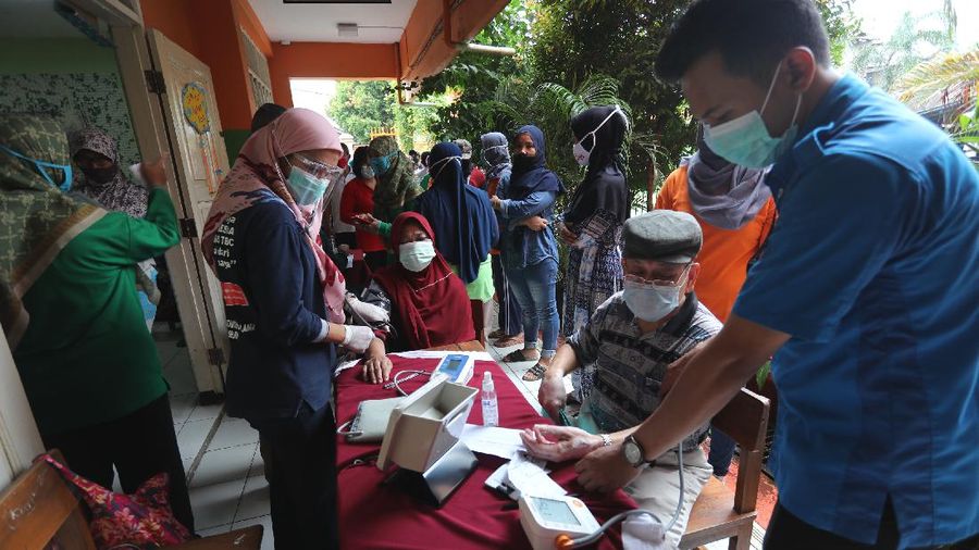 Sejumlah lansia mengantri untuk penyuntikan vaksin covid-19 di SDN 17 Pagi, Kebayoran Lama, Jakarta, Selasa (30/3/2021). Pemerintah kota DKI Jakarta Selatan menjemput warga (lansia) untuk mempercepat vaksinasi Covid-19. (CNBC Indonesia/Tri Susilo)