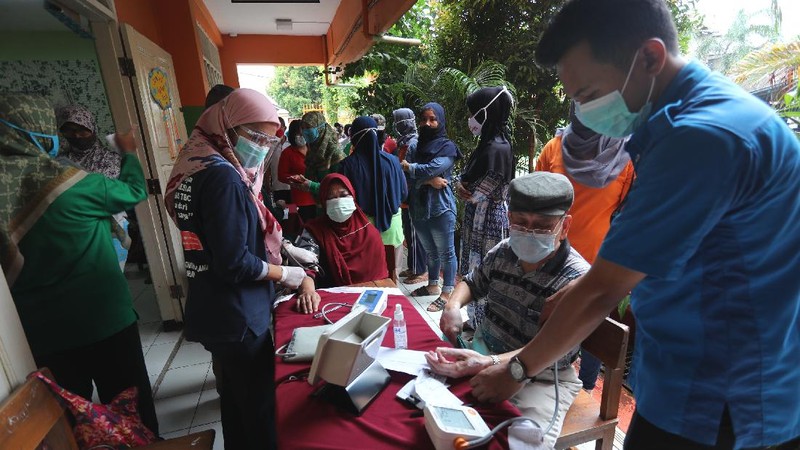 Sejumlah lansia mengantri untuk penyuntikan vaksin covid-19 di SDN 17 Pagi, Kebayoran Lama, Jakarta, Selasa (30/3/2021). Pemerintah kota DKI Jakarta Selatan menjemput warga (lansia) untuk mempercepat vaksinasi Covid-19. (CNBC Indonesia/Tri Susilo)