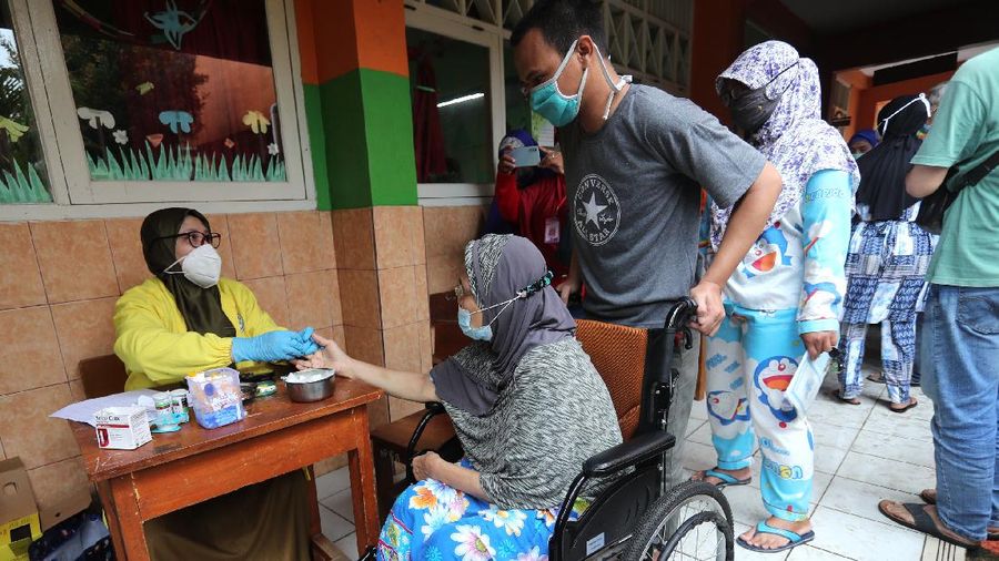 Sejumlah lansia mengantri untuk penyuntikan vaksin covid-19 di SDN 17 Pagi, Kebayoran Lama, Jakarta, Selasa (30/3/2021). Pemerintah kota DKI Jakarta Selatan menjemput warga (lansia) untuk mempercepat vaksinasi Covid-19. (CNBC Indonesia/Tri Susilo)