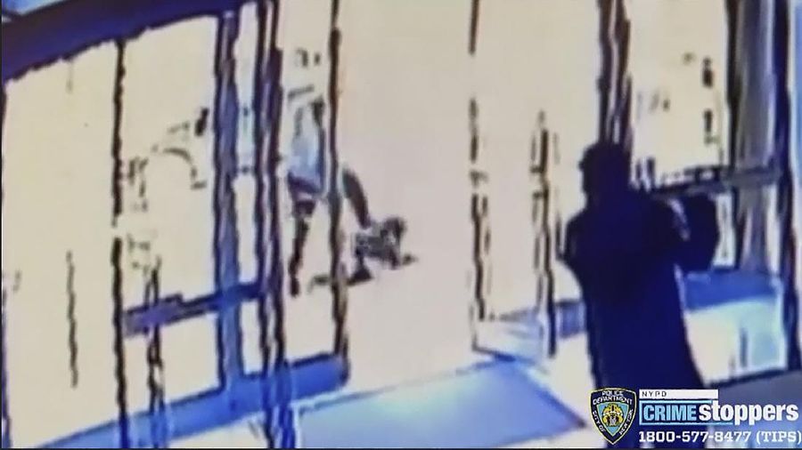 This image taken from surveillance video provided by the New York City Police Department shows a person of interest, background center, assaulting an Asian American woman, on ground, Monday, March 29, 2021, in New York. The 65-year-old woman was walking in midtown Manhattan a few blocks from Times Square on Monday afternoon when a man approached her and kicked her in the stomach, knocking her to the ground, police said.  (Courtesy of New York Police Department via AP)
