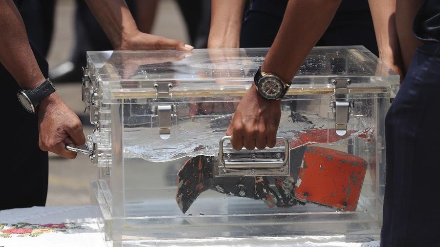 National Transportation Safety Committee investigators carry a box containing the cockpit voice recorder of Sriwijaya Air flight SJ-182 retrieved from the waters off Java Island where the passenger jet crashed in January, during a press conference at Tanjung Priok Port in Jakarta, Indonesia, Wednesday, March 31, 2021. (AP Photo/Tatan Syuflana)