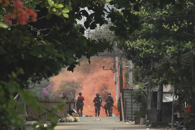In this photo provided by the Karenni Nationalities Defense Force (KNDF), smokes and flames billow from vehicles in Hpruso township, Kayah state, Myanmar, Friday, Dec. 24, 2021. Myanmar government troops rounded up villagers, some believed to be women and children, fatally shot more than 30 and set the bodies on fire, a witness and other reports said Saturday. (KNDF via AP)