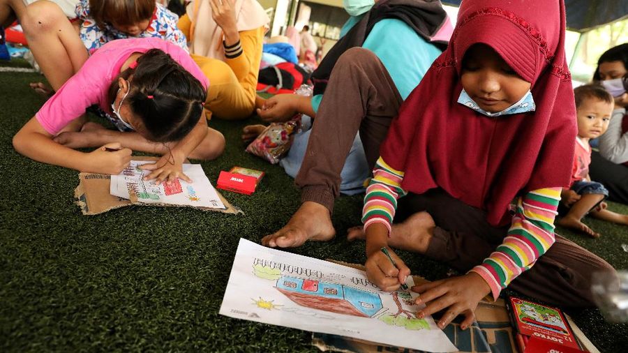 Sejumlah anak pengungsi dari kebakaran kilang Pertamina Balongan Indramayu mewarnai saat berada di tempat pengungsian di Lapangan Futsal GOR Bumi Patra, Indramayu, Jawa Barat, Rabu (31/3/2021). Kegiatan  mewarnai tersebut menjadi salah satu upaya penyembuhan trauma (trauma healing) yang diberikan oleh para relawan agar sejumlah anak-anak tetap ceria saat berada di lokasi pengungsian. (CNBC Indonesia/Andrean Kristianto)