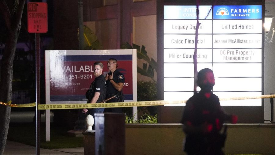 Unidentified people comfort each other as they stand near a business building where a shooting occurred in Orange, Calif., Wednesday, March 31, 2021. Police say several people were killed, including a child, and the suspected shooter was wounded by police. (AP Photo/Jae C. Hong)