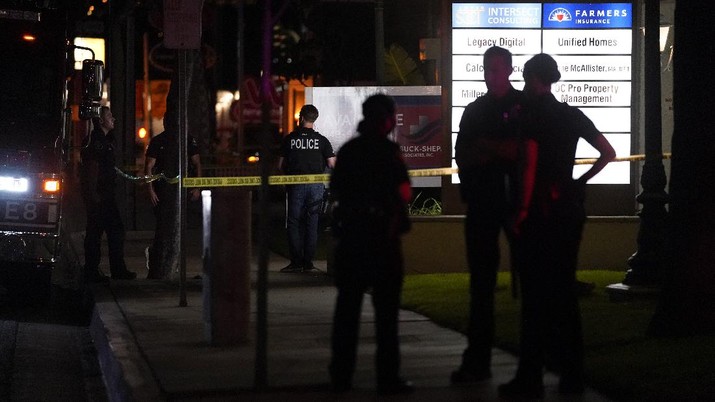 Police officers stand outside a business building where a shooting occurred in Orange, Calif., Wednesday, March 31, 2021. Police say several people were killed, including a child, and the suspected shooter was wounded by police. (AP Photo/Jae C. Hong)