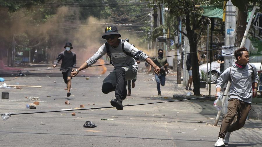Anti-coup protesters run to avoid military forces during a demonstration in Yangon, Myanmar, Wednesday March 31, 2021. The Southeast Asian nation has been wracked by violence since the military ousted a civilian-led government on Feb. 1 and began to forcibly put down protests. (AP Photo)