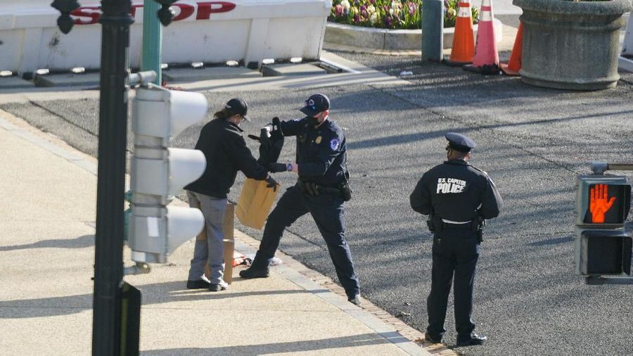 Authorities investigate the scene after a man rammed a car into two officers at the barricade on Capitol Hill in Washington, Friday, April 2, 2021. (AP Photo/Alex Brandon)