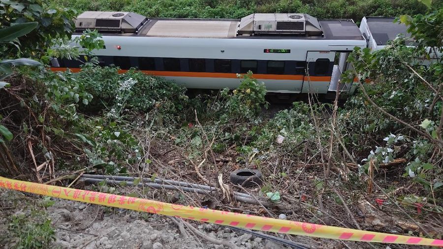 A team of rescue workers change shift from working on the derailed train near the Taroko Gorge area in Hualien, Taiwan on Friday, April 2, 2021. The train partially derailed in eastern Taiwan on Friday after colliding with an unmanned vehicle that had rolled down a hill, killing and injuring dozens. (AP Photo/Chiang Ying-ying)