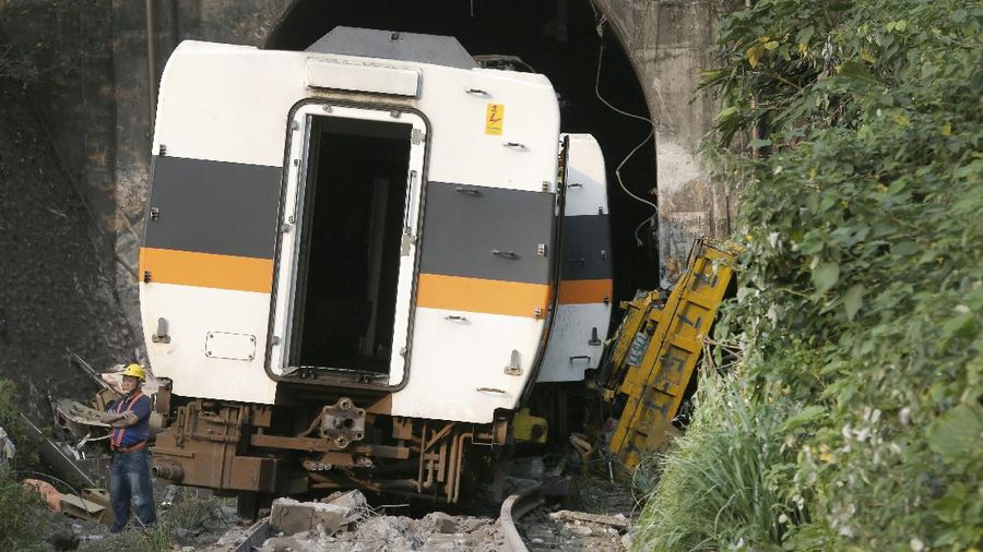 Rescue workers work at the derailed train near Taroko Gorge in Hualien, Taiwan on Friday, April 2, 2021. The train partially derailed in eastern Taiwan on Friday after colliding with an unmanned vehicle that had rolled down a hill, killing and injuring dozens. (AP Photo/Chiang Ying-ying)