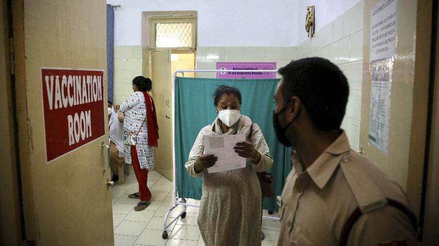 People wearing masks queue up to board buses in Mumbai, India, Monday, April 5, 2021. India reported its biggest single-day spike in confirmed coronavirus cases since the pandemic began Monday, and officials in the hard-hit state home to Mumbai are returning to the closure of some businesses and places of worship in a bid to slow the spread. (AP Photo/Rafiq Maqbool)