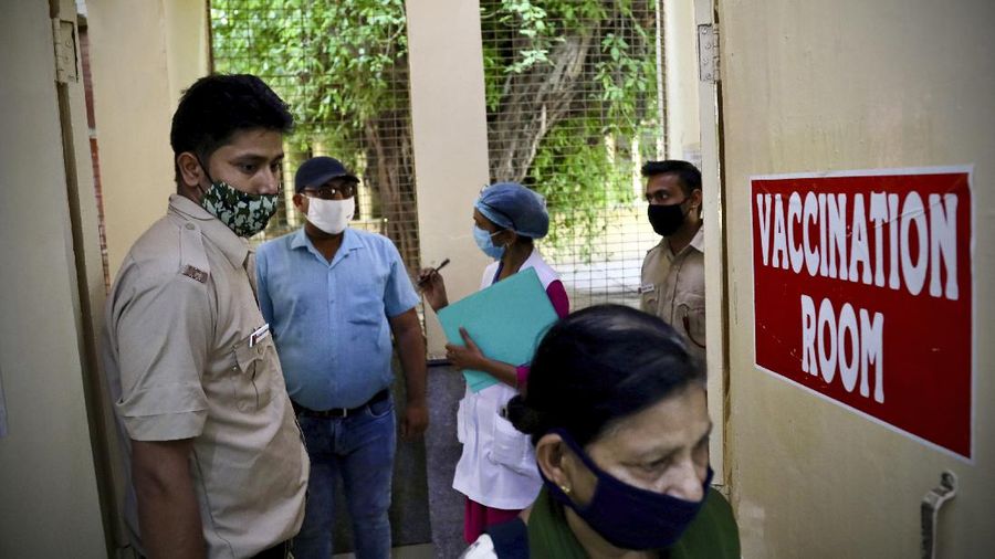 People wearing masks queue up to board buses in Mumbai, India, Monday, April 5, 2021. India reported its biggest single-day spike in confirmed coronavirus cases since the pandemic began Monday, and officials in the hard-hit state home to Mumbai are returning to the closure of some businesses and places of worship in a bid to slow the spread. (AP Photo/Rafiq Maqbool)