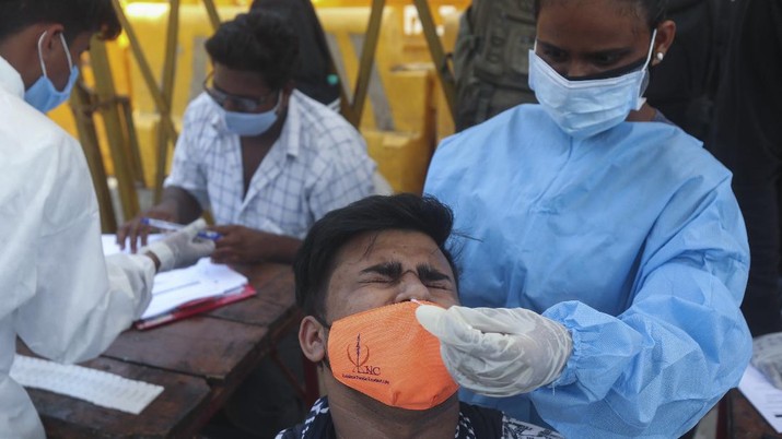 Vaksinasi Warga India A health worker takes a nasal swab sample of a man to test for COVID-19 in Mumbai, India, Monday, April 5, 2021. India reported its biggest single-day spike in confirmed coronavirus cases since the pandemic began Monday, and officials in the hard-hit state home to Mumbai are returning to the closure of some businesses and places of worship in a bid to slow the spread. (AP Photo/Rafiq Maqbool)
