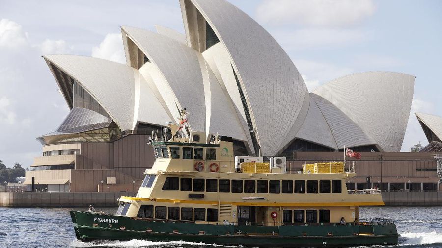 A ferry sails past the Opera House in Sydney, Australia, Tuesday, April 6, 2021. New Zealand announced the start date for a long-anticipated travel bubble between Australia and New Zealand that will allow people to travel between the two countries without going through quarantine, allowing families to reunite and giving a big boost to the struggling tourism industry will begin April 19. (AP Photo/Rick Rycroft)