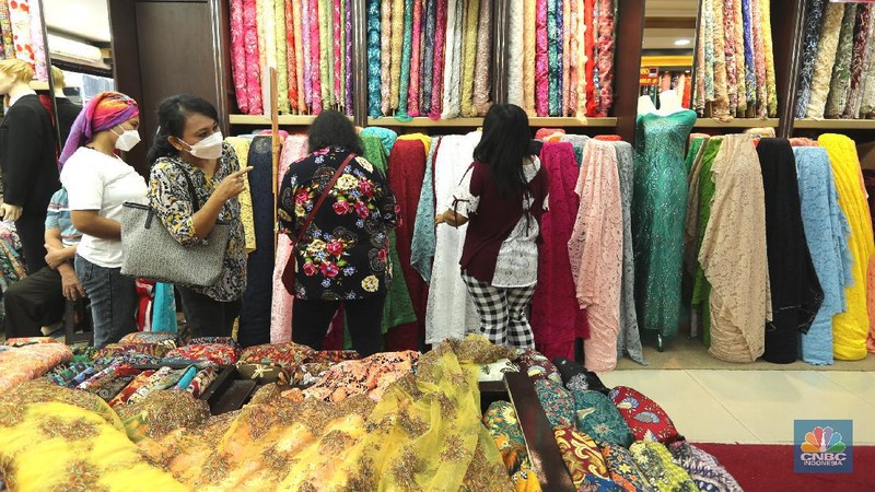 Pembeli memilih kain di salah satu toko tekstil di Pasar Baru, Jakarta, Selasa (6/4/2021). Pemerintah didesak untuk segera memberlakukan penerapan safequard atau perlindungan karena makin markanya produksi tekstil impor di Indonesia. Sekjen Asosiasi Pertekstilan Indonesia, Rizal Tanzil Rakhman menyebutkan bahwa industri tekstil dan produk tekstil (TPT) sektor kain atau garmen saat ini tengah menghadapi gempuran impor kain yang mencapai 46 persen. Pantauan CNBC Indonesia kain didatangkan langsung dari Tiongkok, India dan Italia (CNBC Indonesia/ Tri Susilo)