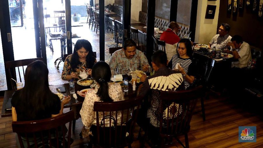 Petugas membersihkan meja makanan di Restoran di Kawasan Benhil, Jakarta, Selasa 6/4. Perhimpunan Hotel dan Restoran Indonesia (PHRI) Jakarta ingin pemerintah meningkatkan kapasitas jumlah pengunjung yang bisa makan di tempat alias dine in di tempat makan menjadi 75 persen saat masa buka bersama (bukber) puasa sepanjang Ramadan. Saat ini, kapasitas pengunjung dine in hanya boleh 50 persen. Kebijakan ini diterapkan karena pemerintah masih melangsungkan Pemberlakuan Pembatasan Kegiatan Masyarakat (PPKM) Mikro. Terkait hal ini, Pelaksana Tugas (Plt) Kepala Dinas Pariwisata dan Ekonomi Kreatif DKI Jakarta Gumilar Ekalaya mengatakan belum ada perubahan aturan terkait kapasitas jam operasional restoran saat momen buka puasa bersama seperti dikutip CNN Indonesia. Namun, pemerintah tetap membuka masukan dari pengusaha. Pelaksana tugas (Plt) Kepala Dinas Pariwisata dan Ekonomi Kreatif DKI Jakarta, Gumilar Ekalaya juga mengatakan pihaknya tidak melarang pelaksanaan kegiatan buka puasa bersama (bukber) di restoran atau rumah makan di masa pandemi Covid-19. Menurut Gumilar, waktu pelaksanaan kegiatan bukber tidak melanggar ketentuan dalam PPKM Mikro. Meski tidak melarang, Gumilar mengingatkan kegiatan buka bersama harus tetap menerapkan protokol kesehatan. (CNBC Indonesia/Muhammad Sabki)