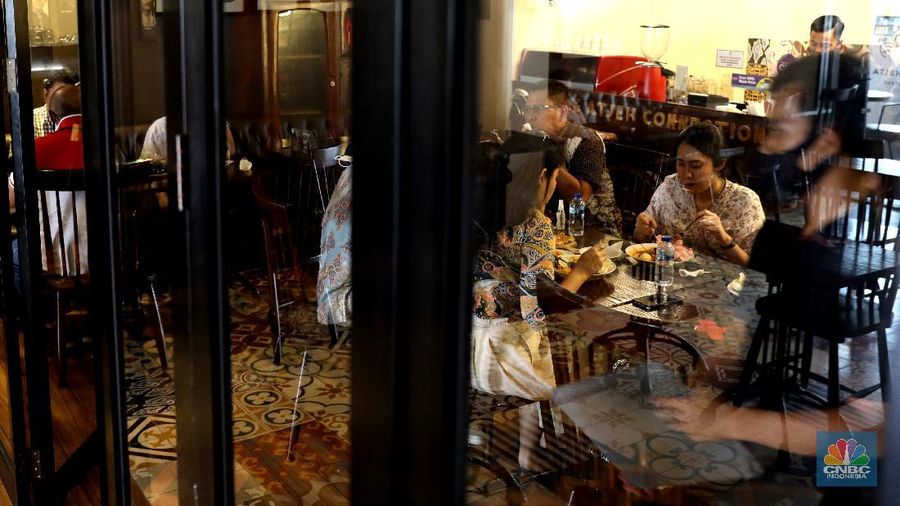 Petugas membersihkan meja makanan di Restoran di Kawasan Benhil, Jakarta, Selasa 6/4. Perhimpunan Hotel dan Restoran Indonesia (PHRI) Jakarta ingin pemerintah meningkatkan kapasitas jumlah pengunjung yang bisa makan di tempat alias dine in di tempat makan menjadi 75 persen saat masa buka bersama (bukber) puasa sepanjang Ramadan. Saat ini, kapasitas pengunjung dine in hanya boleh 50 persen. Kebijakan ini diterapkan karena pemerintah masih melangsungkan Pemberlakuan Pembatasan Kegiatan Masyarakat (PPKM) Mikro. Terkait hal ini, Pelaksana Tugas (Plt) Kepala Dinas Pariwisata dan Ekonomi Kreatif DKI Jakarta Gumilar Ekalaya mengatakan belum ada perubahan aturan terkait kapasitas jam operasional restoran saat momen buka puasa bersama seperti dikutip CNN Indonesia. Namun, pemerintah tetap membuka masukan dari pengusaha. Pelaksana tugas (Plt) Kepala Dinas Pariwisata dan Ekonomi Kreatif DKI Jakarta, Gumilar Ekalaya juga mengatakan pihaknya tidak melarang pelaksanaan kegiatan buka puasa bersama (bukber) di restoran atau rumah makan di masa pandemi Covid-19. Menurut Gumilar, waktu pelaksanaan kegiatan bukber tidak melanggar ketentuan dalam PPKM Mikro. Meski tidak melarang, Gumilar mengingatkan kegiatan buka bersama harus tetap menerapkan protokol kesehatan. (CNBC Indonesia/Muhammad Sabki)