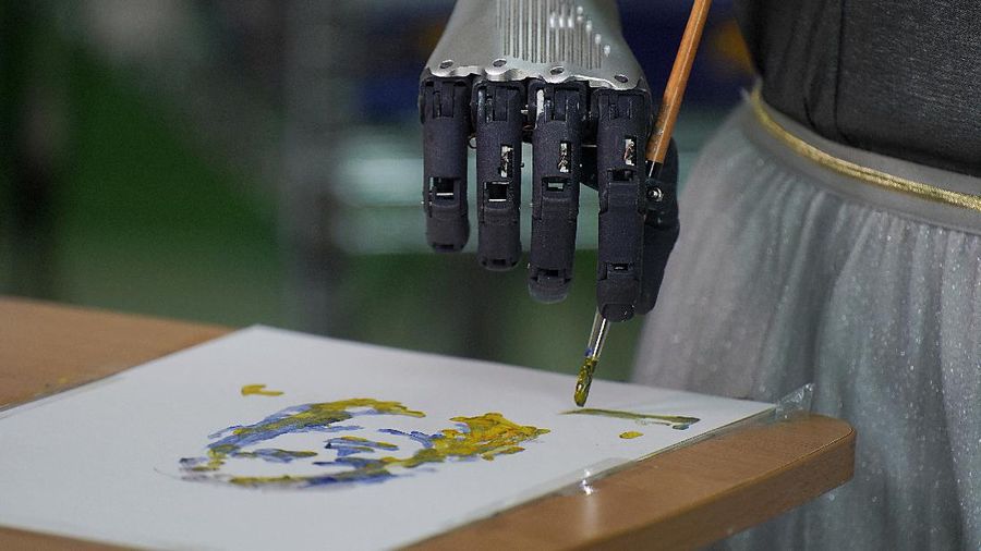 David Hanson, left, creator of Sophia, shows a work of Sophia at his studio in Hong Kong on March 29, 2021. Sophia is a robot of many talents — she speaks, jokes, sings and even makes art. In March, she caused a stir in the art world when a digital work she created as part of a collaboration was sold at an auction for $688,888 in the form of a non-fungible token (NFT).WLD(AP Photo/Vincent Yu)