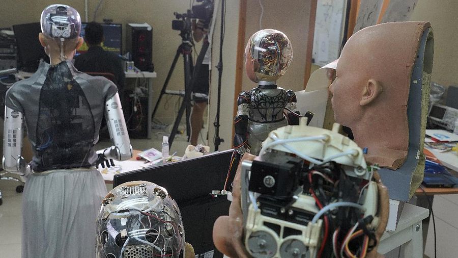 David Hanson, left, creator of Sophia, shows a work of Sophia at his studio in Hong Kong on March 29, 2021. Sophia is a robot of many talents — she speaks, jokes, sings and even makes art. In March, she caused a stir in the art world when a digital work she created as part of a collaboration was sold at an auction for $688,888 in the form of a non-fungible token (NFT).WLD(AP Photo/Vincent Yu)