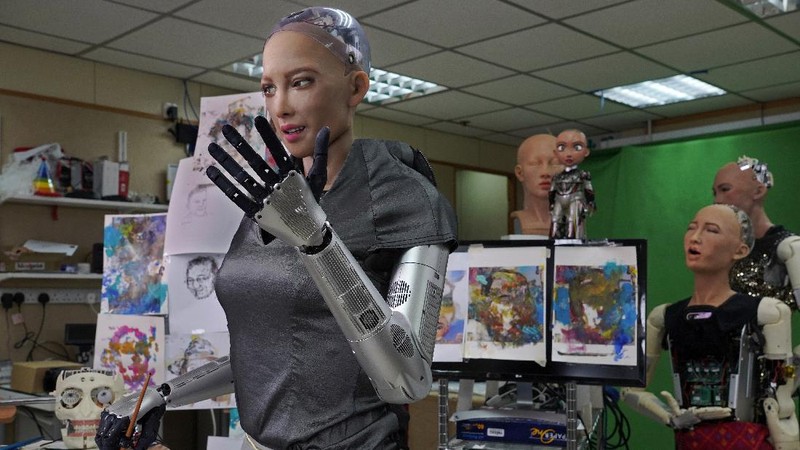 David Hanson, left, creator of Sophia, shows a work of Sophia at his studio in Hong Kong on March 29, 2021. Sophia is a robot of many talents — she speaks, jokes, sings and even makes art. In March, she caused a stir in the art world when a digital work she created as part of a collaboration was sold at an auction for $688,888 in the form of a non-fungible token (NFT).WLD(AP Photo/Vincent Yu)