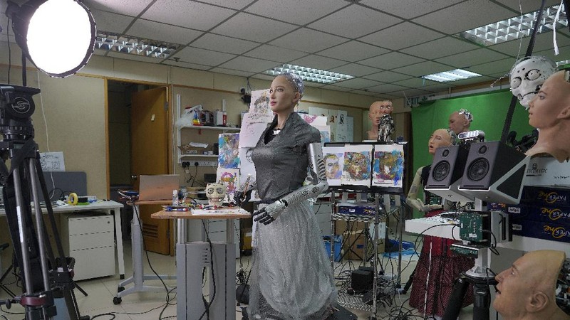 David Hanson, left, creator of Sophia, shows a work of Sophia at his studio in Hong Kong on March 29, 2021. Sophia is a robot of many talents — she speaks, jokes, sings and even makes art. In March, she caused a stir in the art world when a digital work she created as part of a collaboration was sold at an auction for $688,888 in the form of a non-fungible token (NFT).WLD(AP Photo/Vincent Yu)
