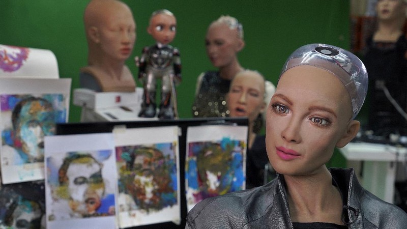 David Hanson, left, creator of Sophia, shows a work of Sophia at his studio in Hong Kong on March 29, 2021. Sophia is a robot of many talents — she speaks, jokes, sings and even makes art. In March, she caused a stir in the art world when a digital work she created as part of a collaboration was sold at an auction for $688,888 in the form of a non-fungible token (NFT).WLD(AP Photo/Vincent Yu)