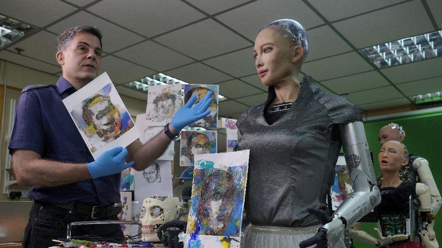 David Hanson, left, creator of Sophia, shows a work of Sophia at his studio in Hong Kong on March 29, 2021. Sophia is a robot of many talents — she speaks, jokes, sings and even makes art. In March, she caused a stir in the art world when a digital work she created as part of a collaboration was sold at an auction for $688,888 in the form of a non-fungible token (NFT).WLD(AP Photo/Vincent Yu)